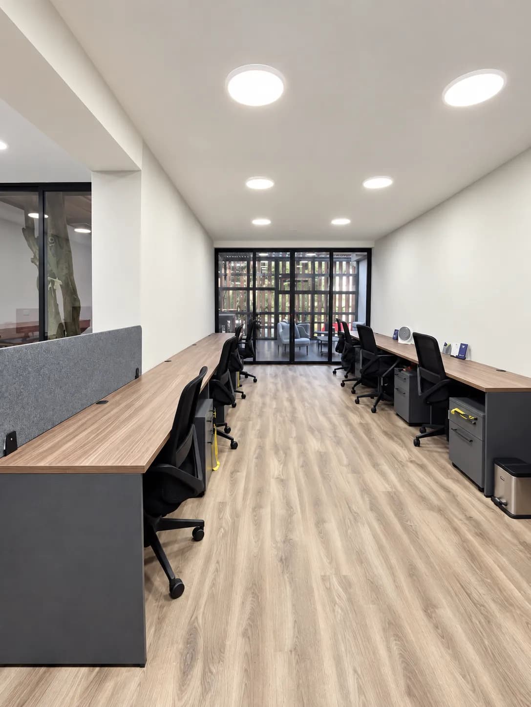 Errece Studios: área operativa con dos filas de estaciones lineales y vista al lounge
