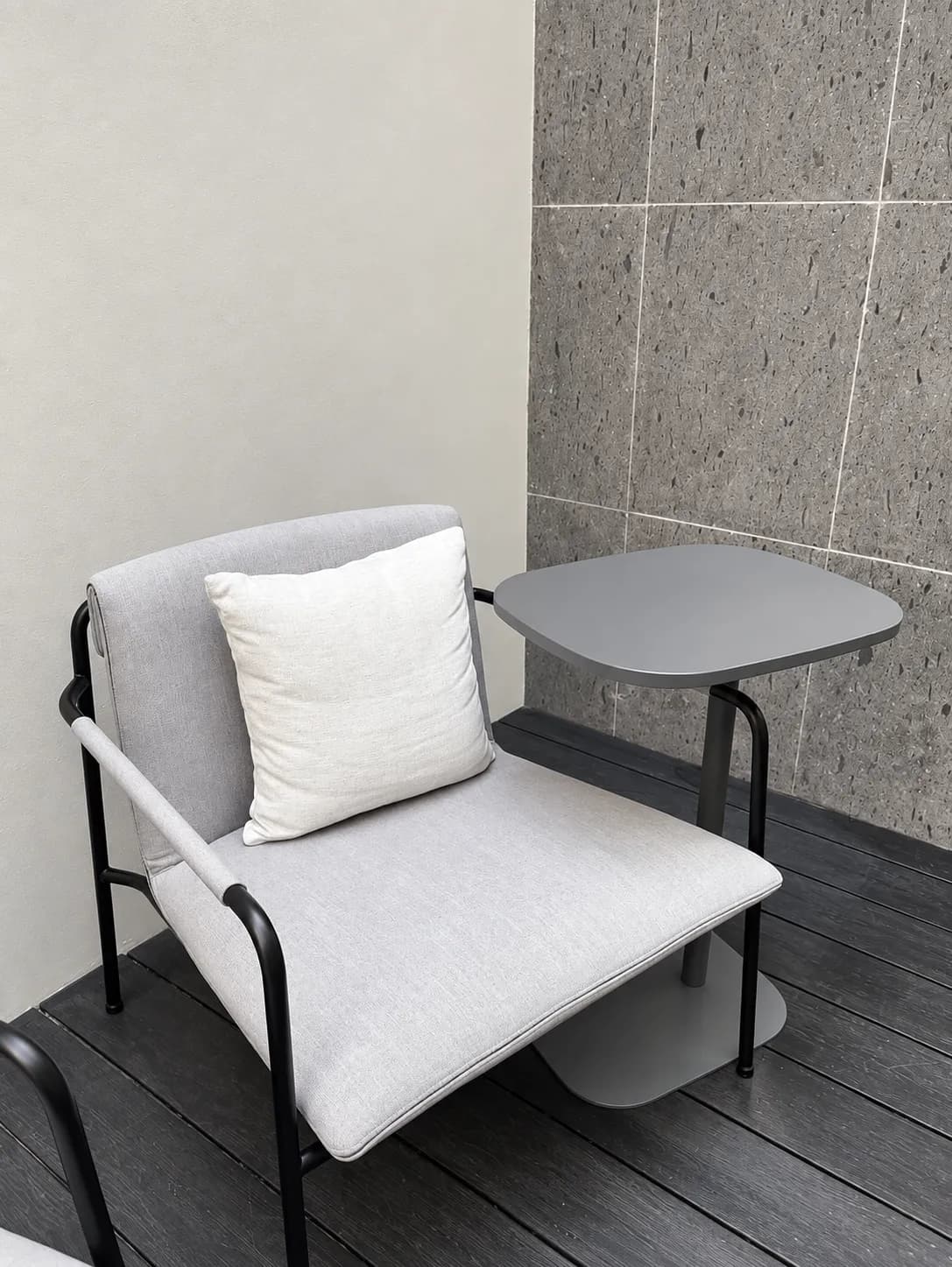 Errece Studios: sillón gris con estructura negra y mesa lateral de apoyo