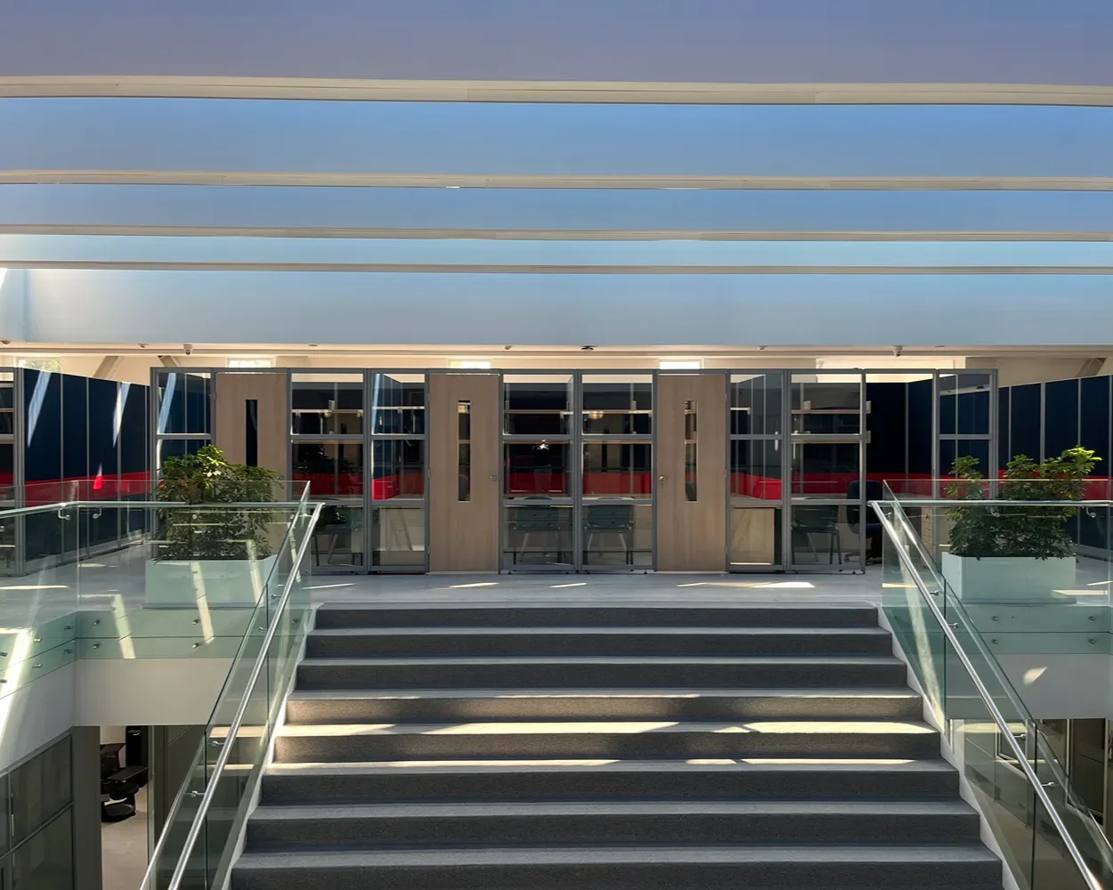 Planta alta de La Salle con privados de cristal y muros divisorios azul y rojo, por Poliarte