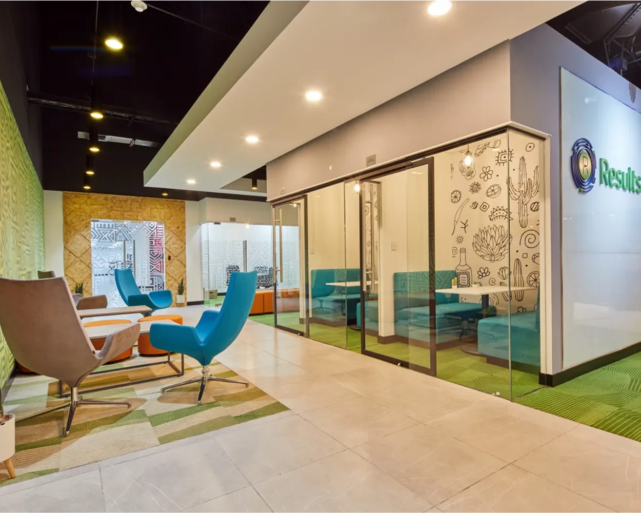 Lounge de Newcore Industries con sillones azules, privados de cristal y bancas turquesa, mobiliario de Poliarte