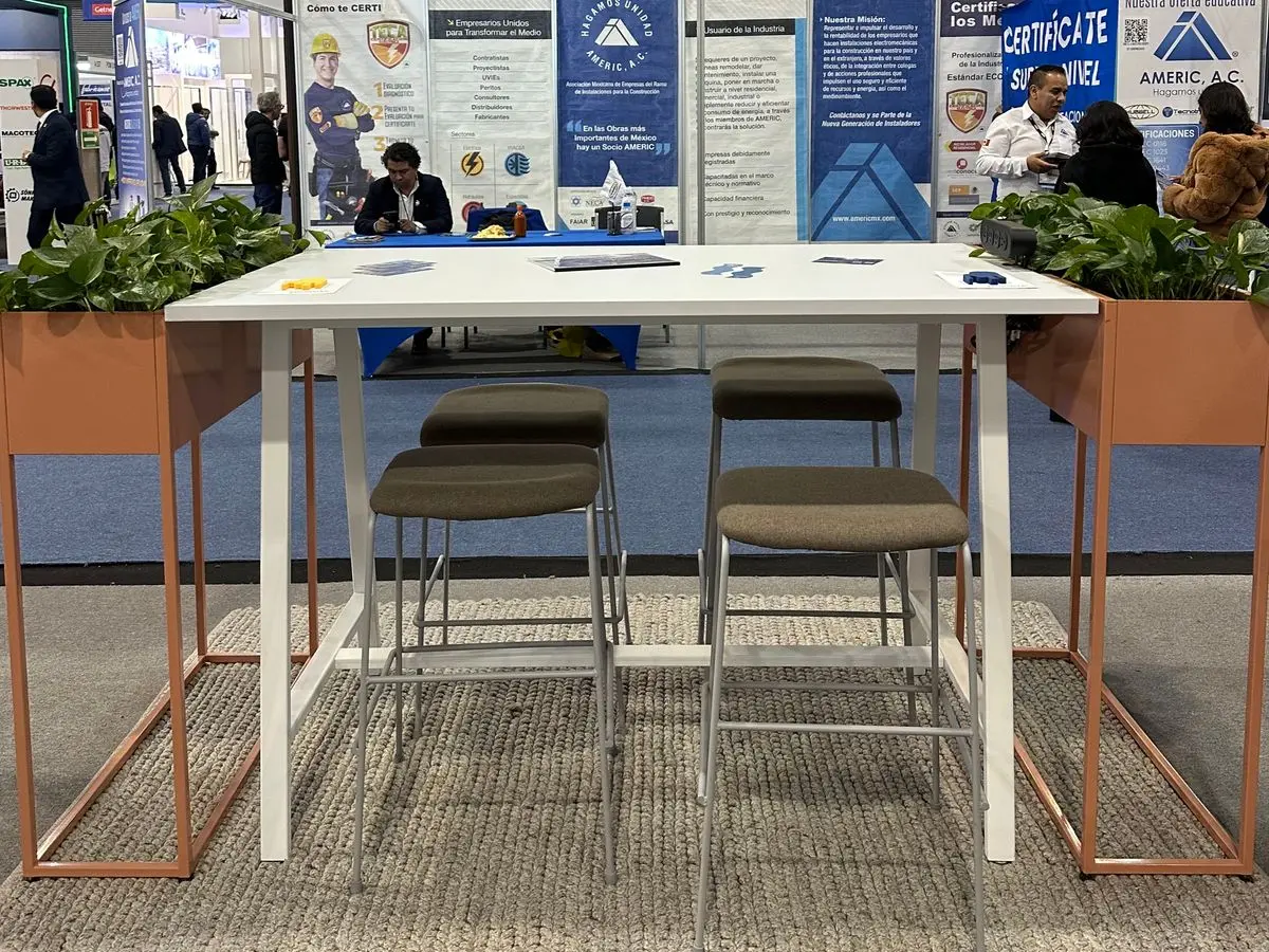 Mesa alta Quadra blanca de Poliarte con bancos altos y maceteros Bio en Expo CIHAC 2026